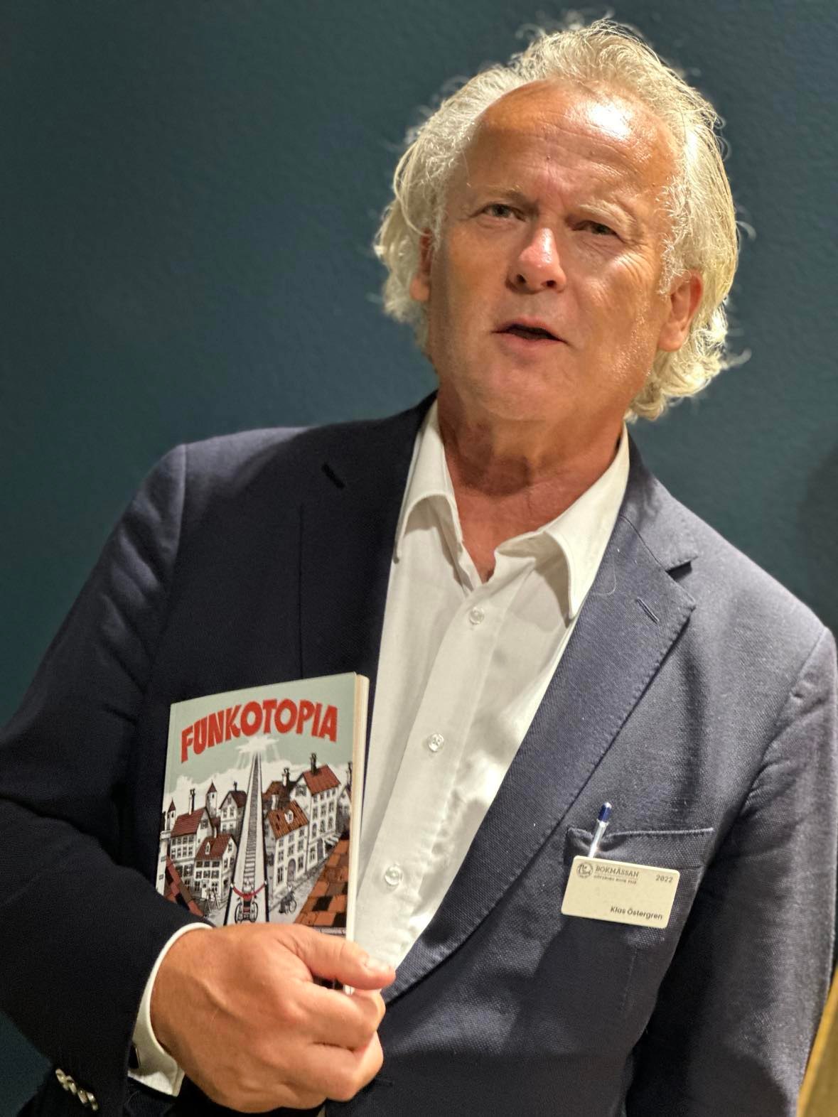 Foto av Klas Östergren som håller upp boken Funkotopia